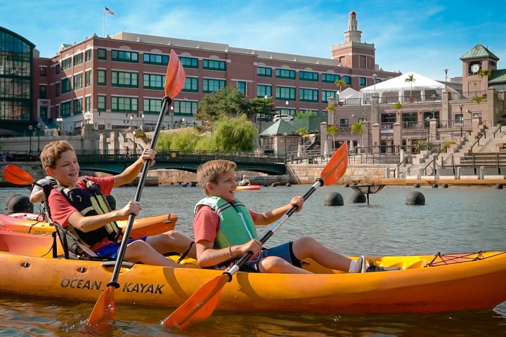 a group of people riding on the back of a boat in the water