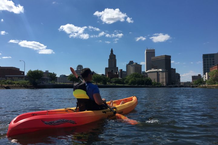 a man riding on the back of a boat in a body of water