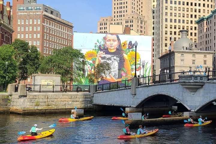 a small boat in a body of water with a city in the background